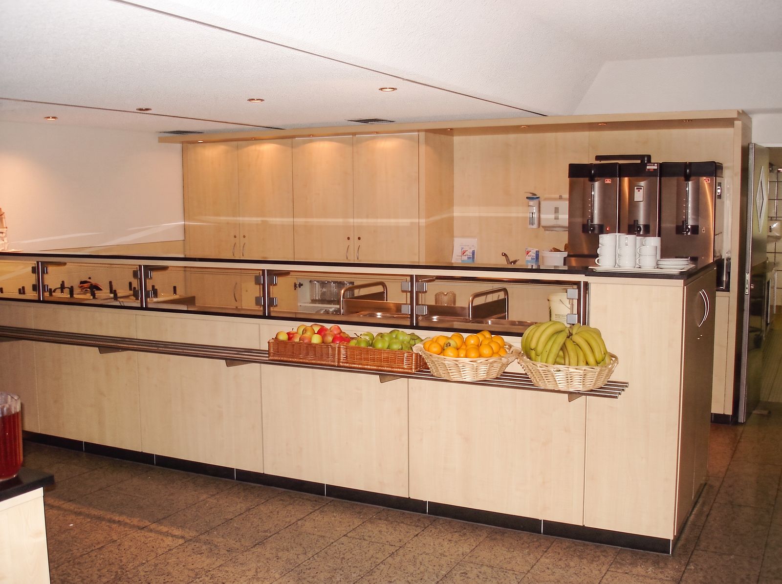 Buffettheke aus Ahorn mit Glasaufsatz, Edelstahlablage und Obstauslage in einer Kantine