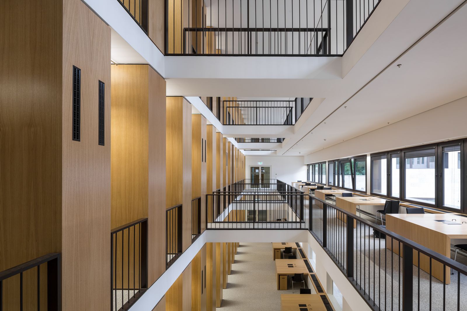 Mehrgeschossige Bibliothek mit Galerien, Holzverkleidung und schwarzen Geländern