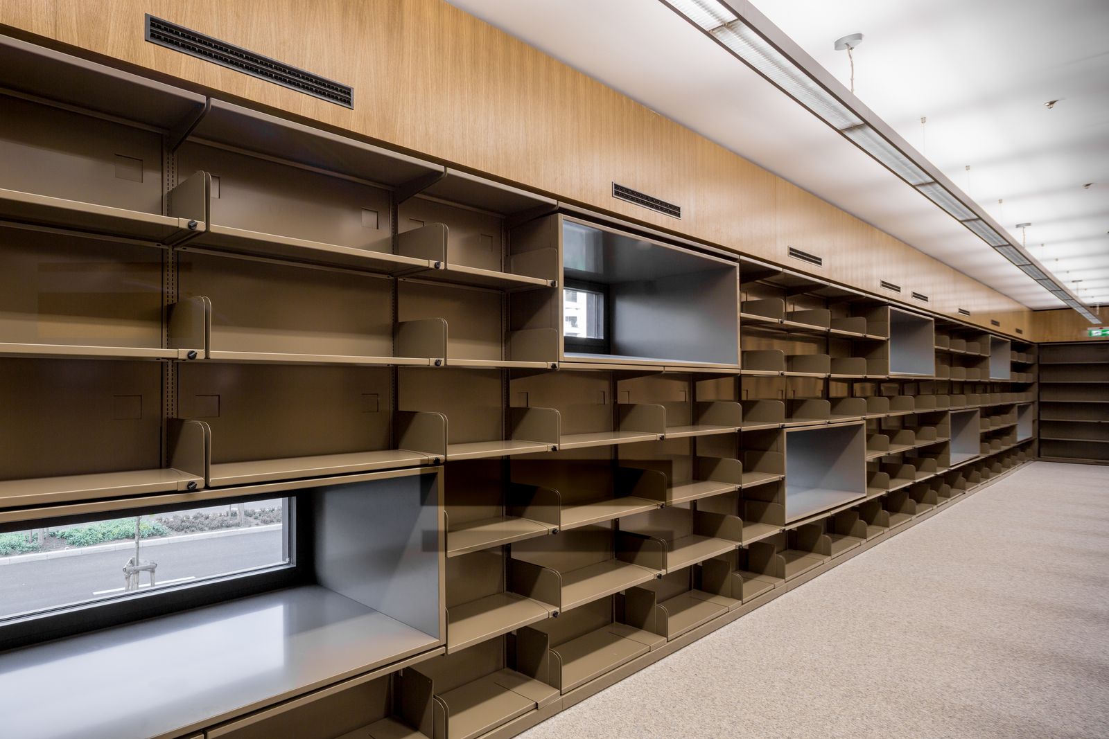 Lange Regalwand aus Eiche mit Fensterband in einer Bibliothek