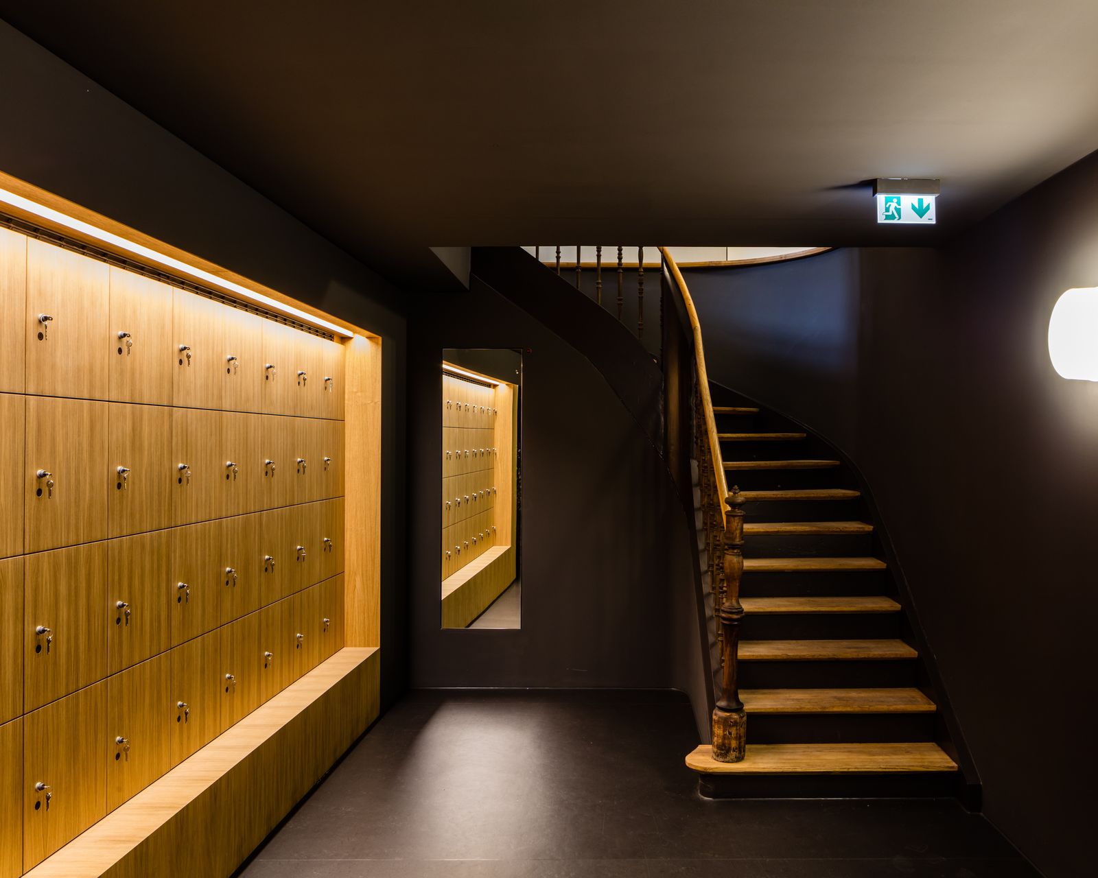 Schließfachwand aus Eiche mit Lichtleiste neben einer historischen Treppe im Museum
