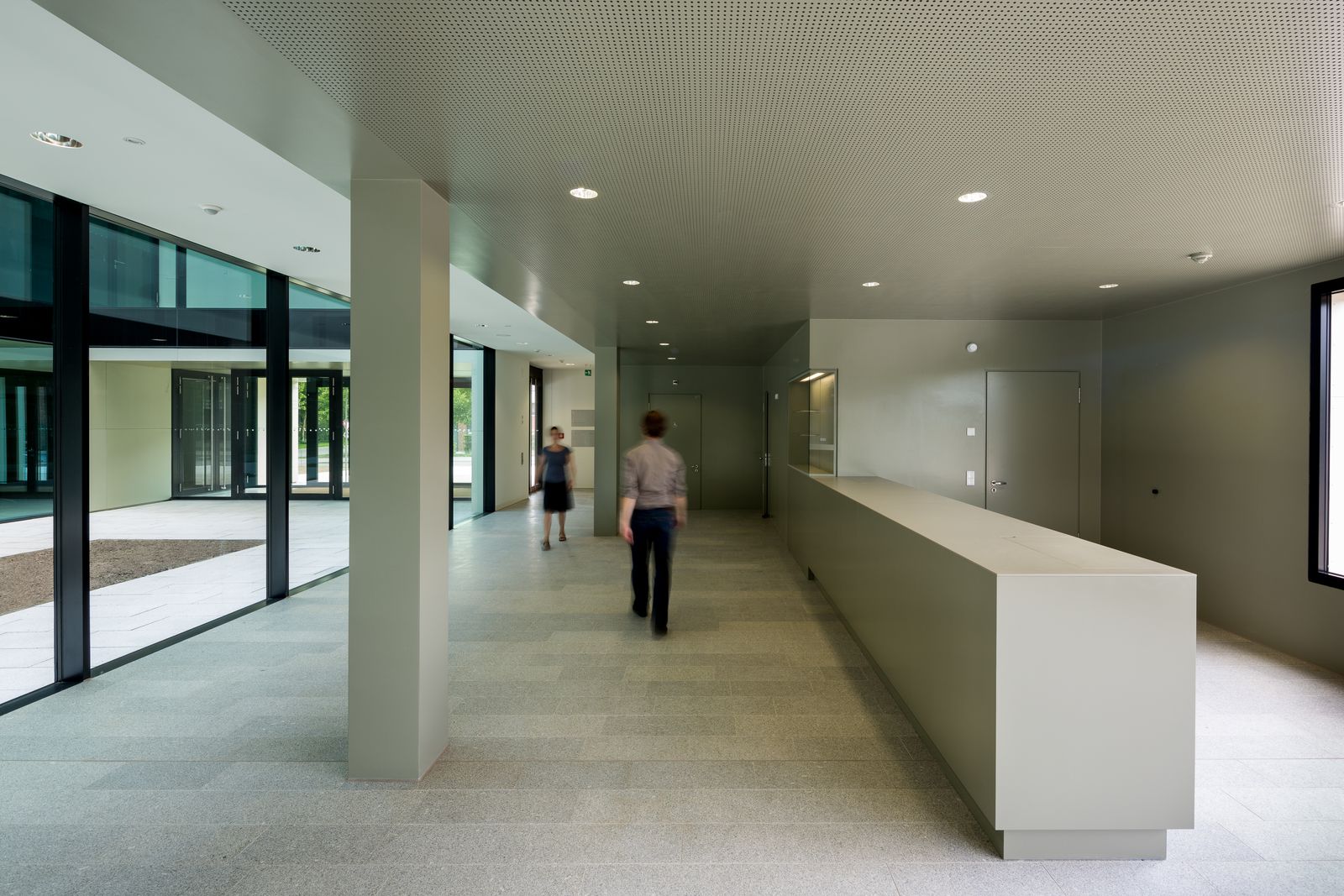 Langes Tresenelement mit Vitrine im Foyer einer Hochschule mit Glasfassade